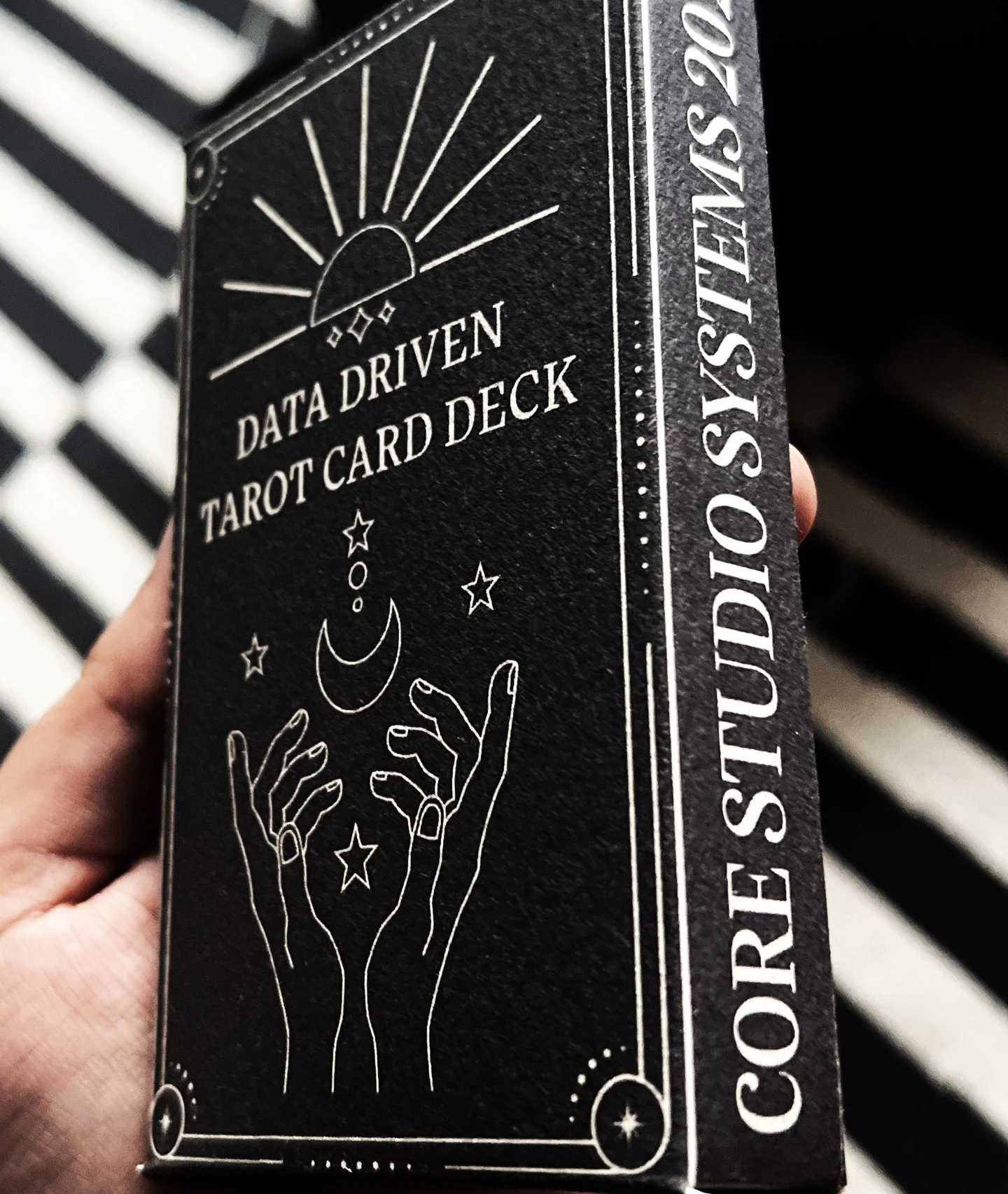 The handmade black tarot deck box held in one hand.
