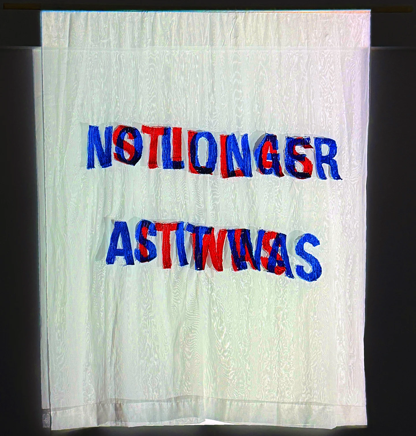 Neutral light: The overlapping red and blue letters remain physically embroidered in the same fabric.